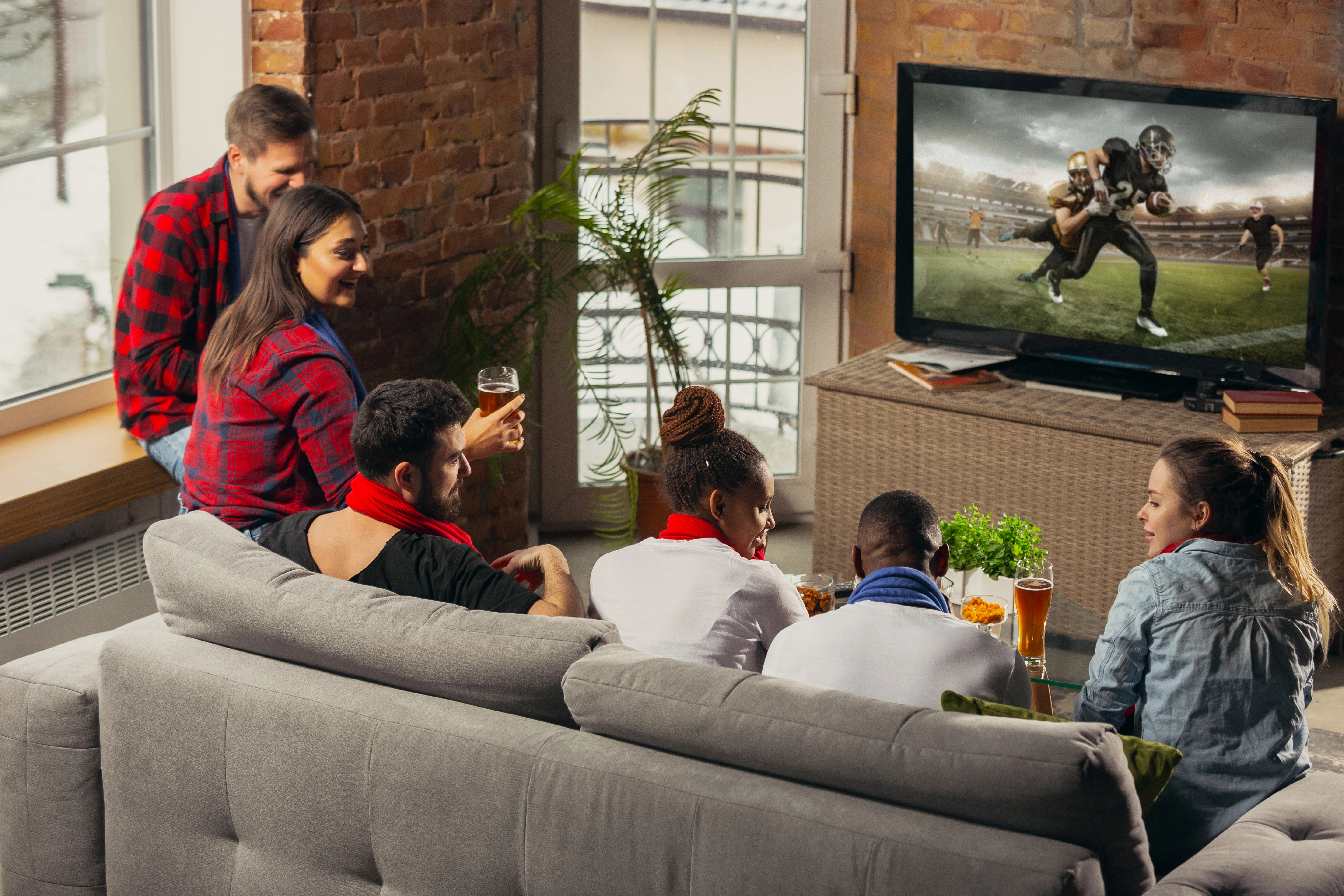 Grupo de personas emocionadas viendo la televisión